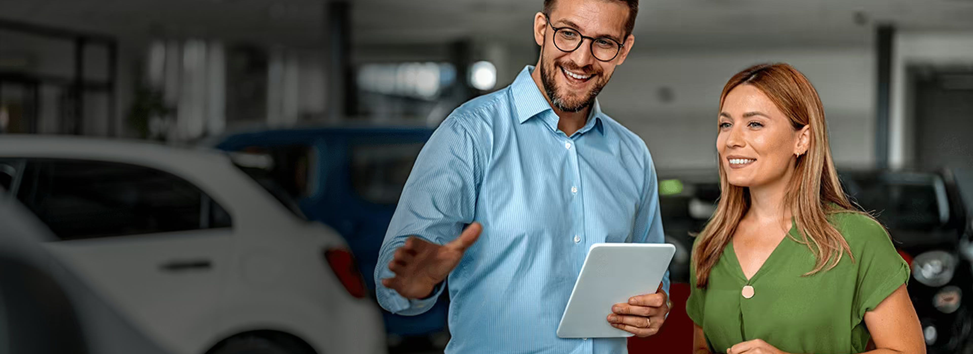 Auto salesperson assisting a customer inside a dealership.