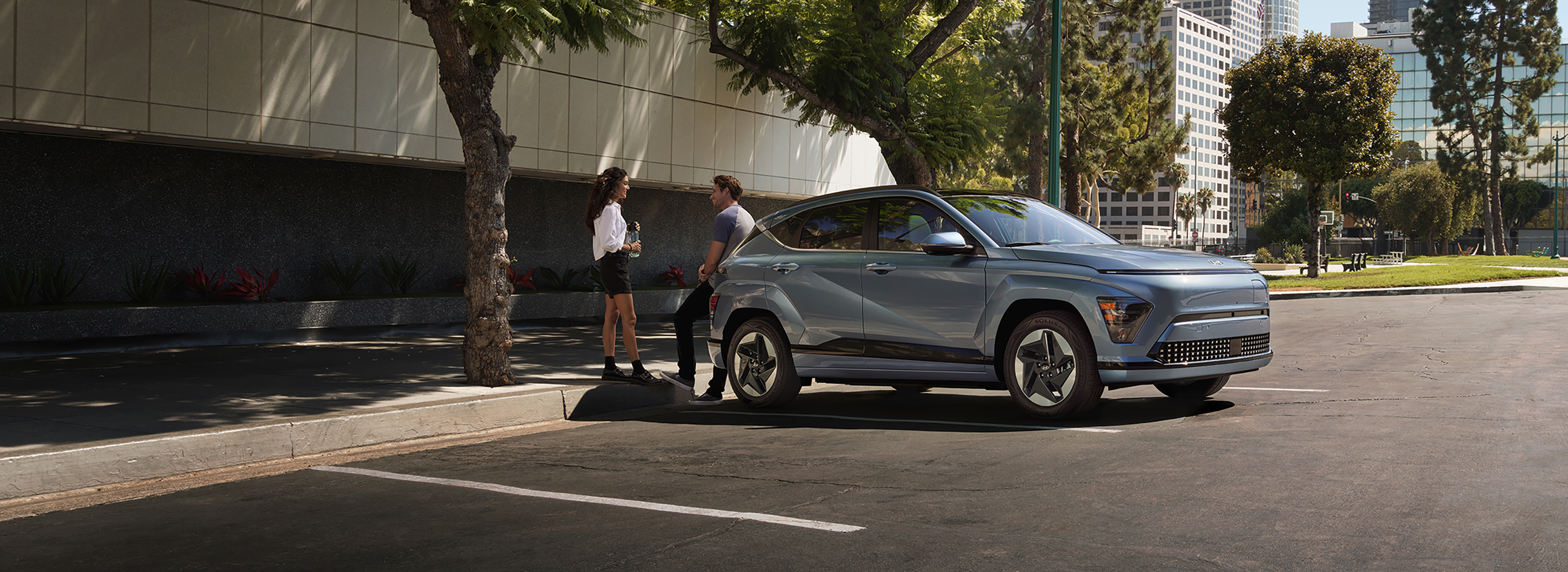 Hyundai SUV parked on a city street with two people talking beside the vehicle.