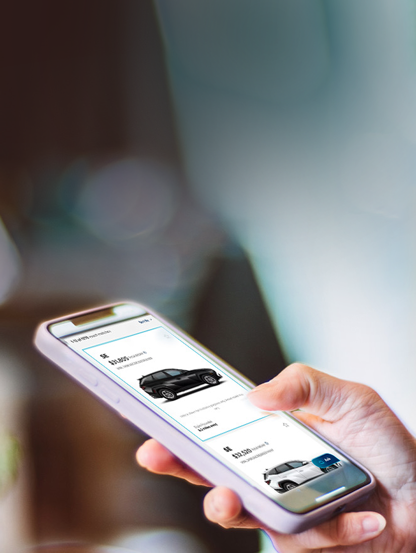 Person browsing vehicle listings on a mobile phone.