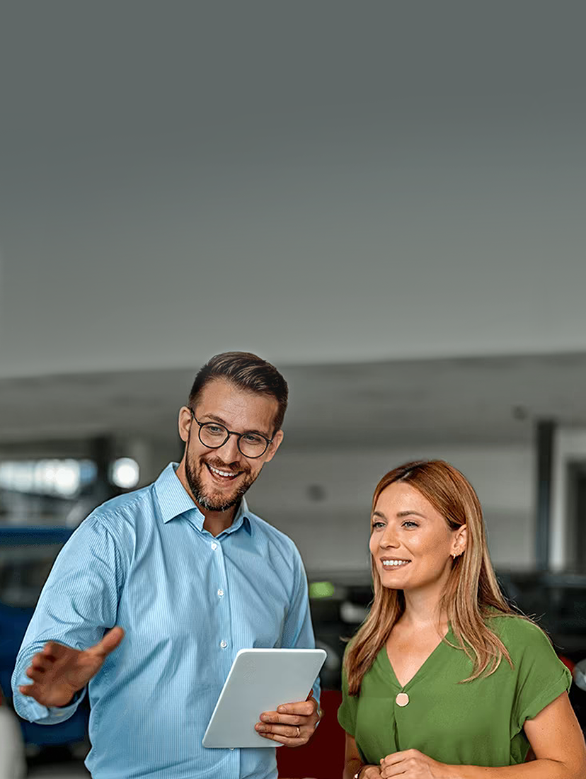 Auto salesperson assisting a customer inside a dealership.